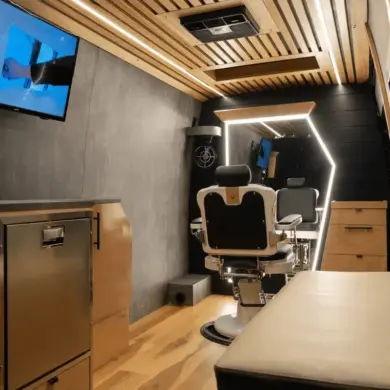 Innenraum eines umgebauten Mercedes Sprinter als mobiler Barbershop mit Barberstuhl, großem Spiegel, TV und moderner Ausstattung.