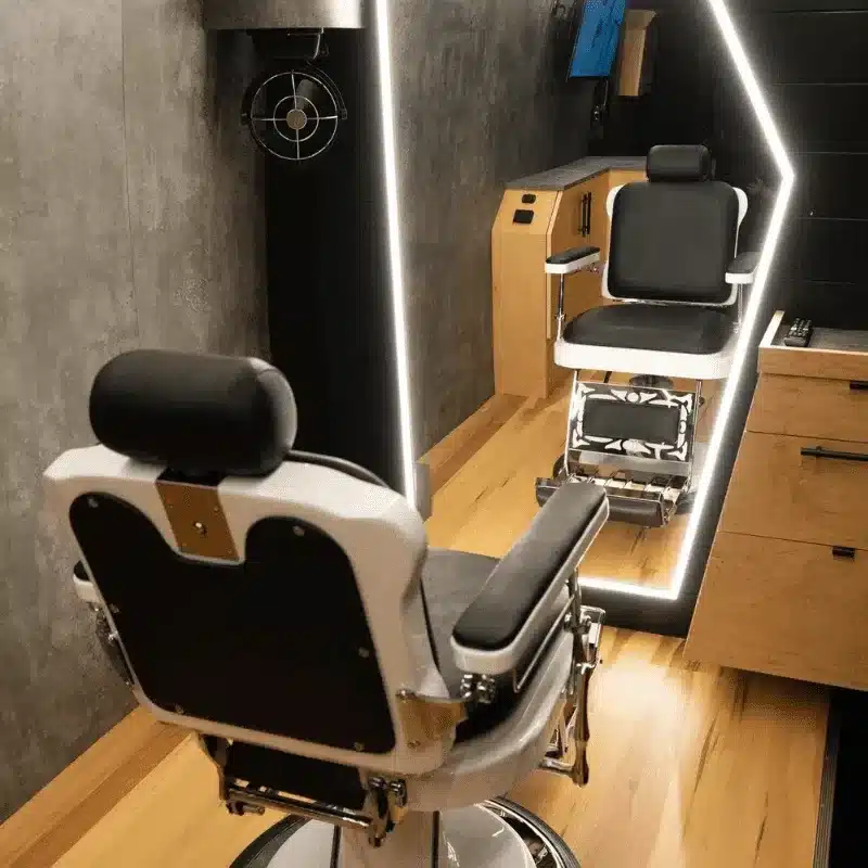 Barberstuhl und beleuchteter Spiegel im Innenraum eines mobilen Barbershops auf Basis eines Mercedes Sprinter.