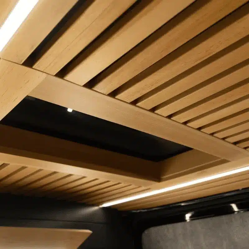 Detailaufnahme der modernen Holzdecke mit LED-Beleuchtung im mobilen Barbershop im Mercedes Sprinter.