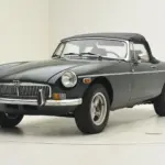 MGB Roadster aus dem Jahr 1980 mit geschlossenem schwarzen Stoffverdeck vor neutralem Hintergrund