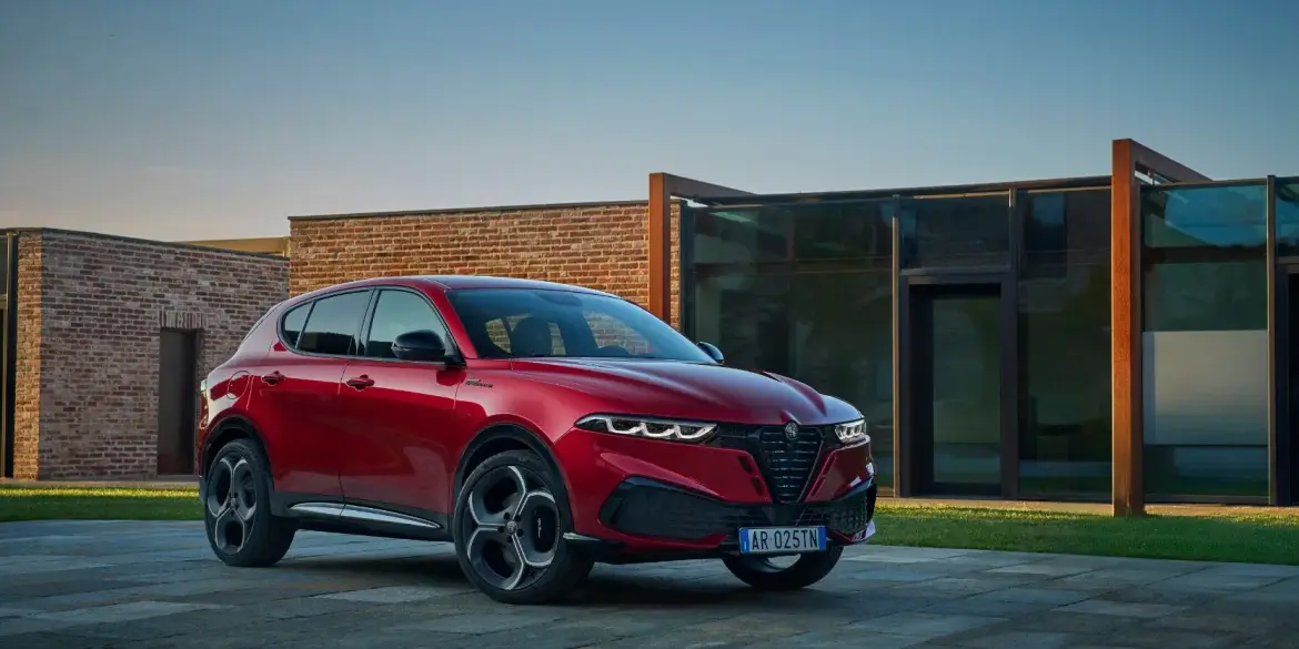 Neuer Alfa Romeo Tonale in roter Lackierung vor einem Gebäude, Frontansicht des kompakten SUV