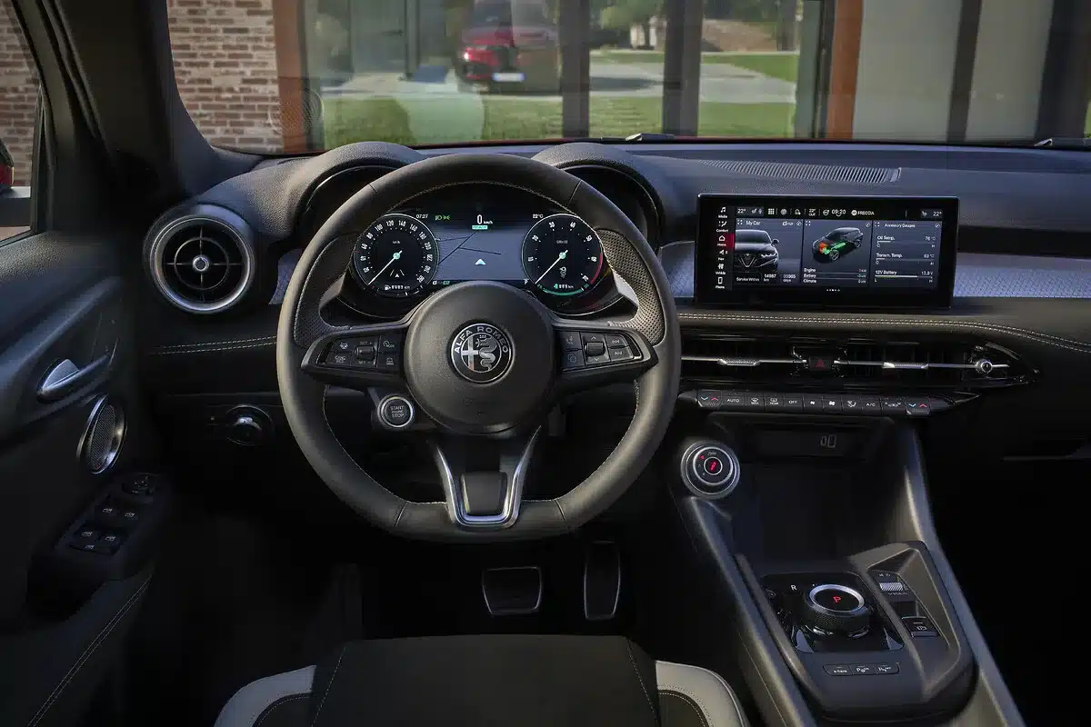 Innenraum des neuen Alfa Romeo Tonale mit Sportlenkrad, digitalen Instrumenten und zentralem Touchscreen.