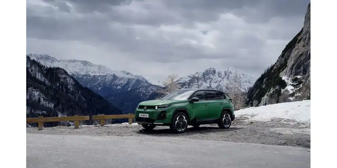 Grüner Citroën C5 Aircross steht auf einer Straße vor schneebedeckten Alpen