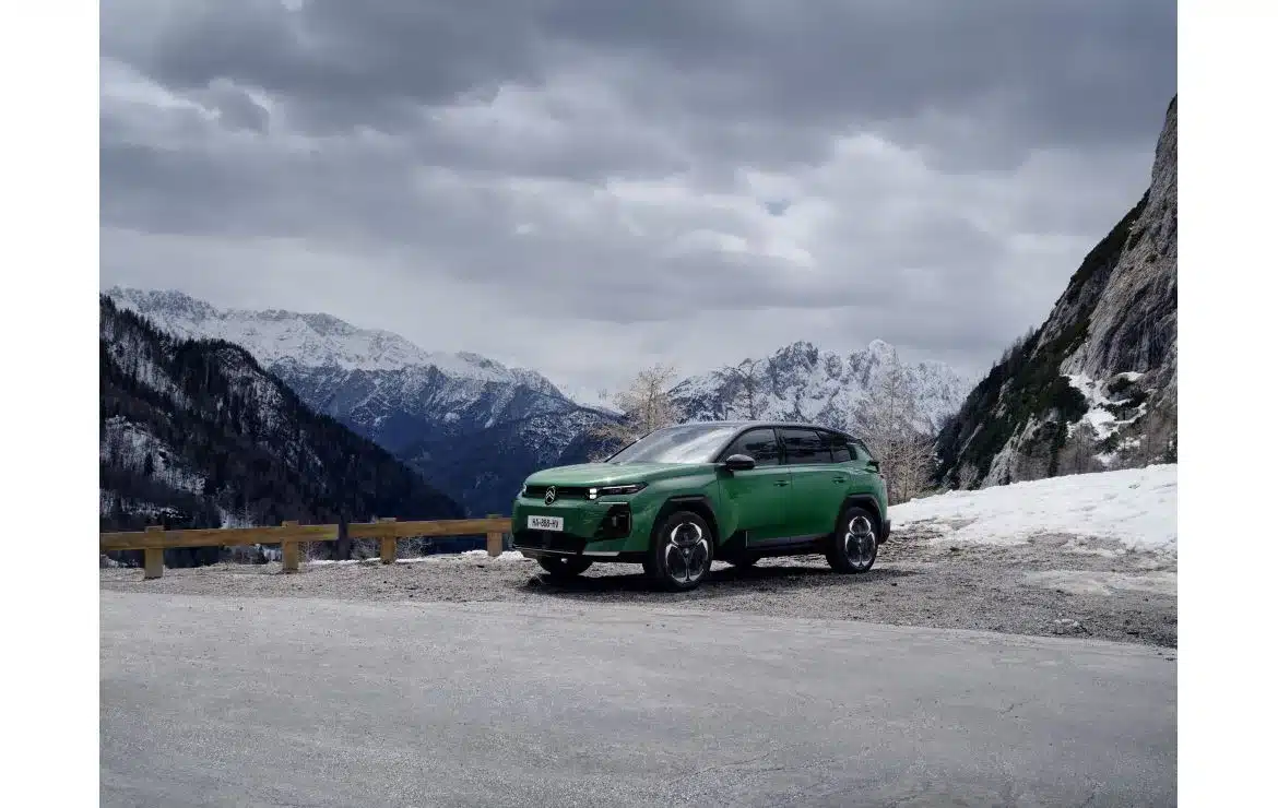 Grüner Citroën C5 Aircross steht auf einer Straße vor schneebedeckten Alpen