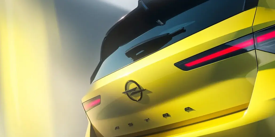Nahaufnahme der Heckpartie eines gelben Opel Astra mit LED-Rückleuchten und Opel-Logo.