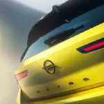 Nahaufnahme der Heckpartie eines gelben Opel Astra mit LED-Rückleuchten und Opel-Logo.