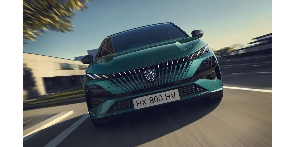 Frontansicht eines grünen Peugeot 308, der auf einer Straße fährt.