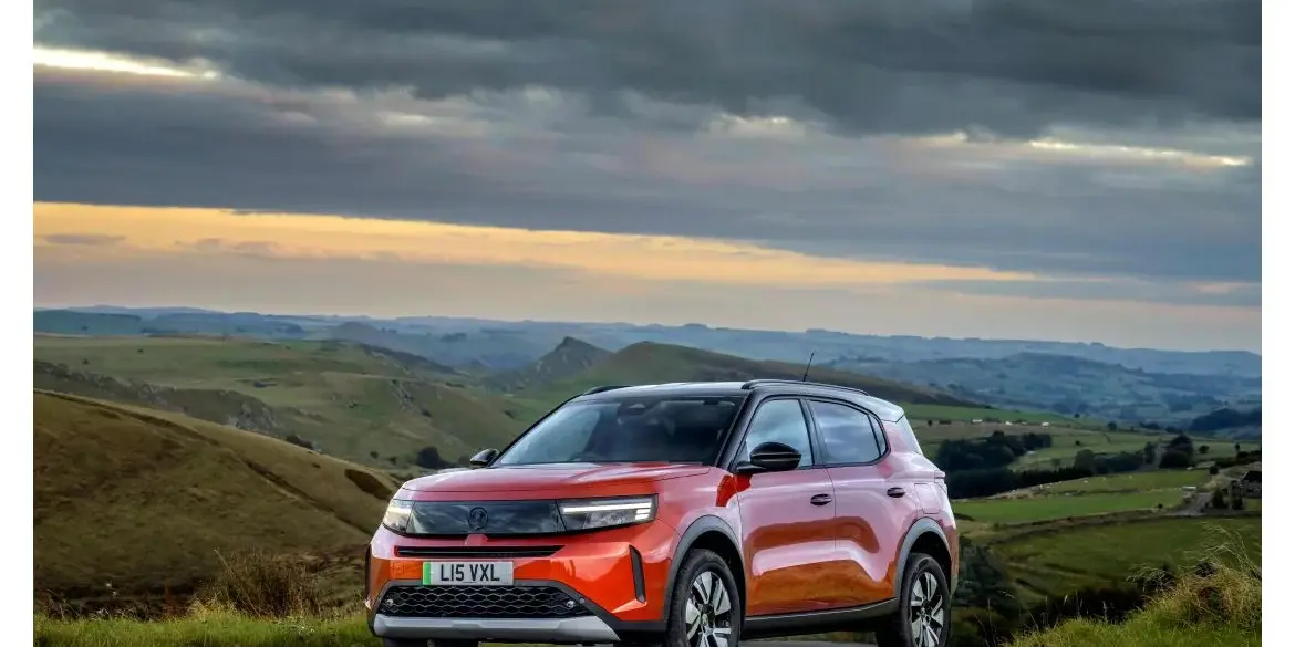 Vauxhall Frontera in Orange vor hügeliger Landschaft bei bewölktem Himmel