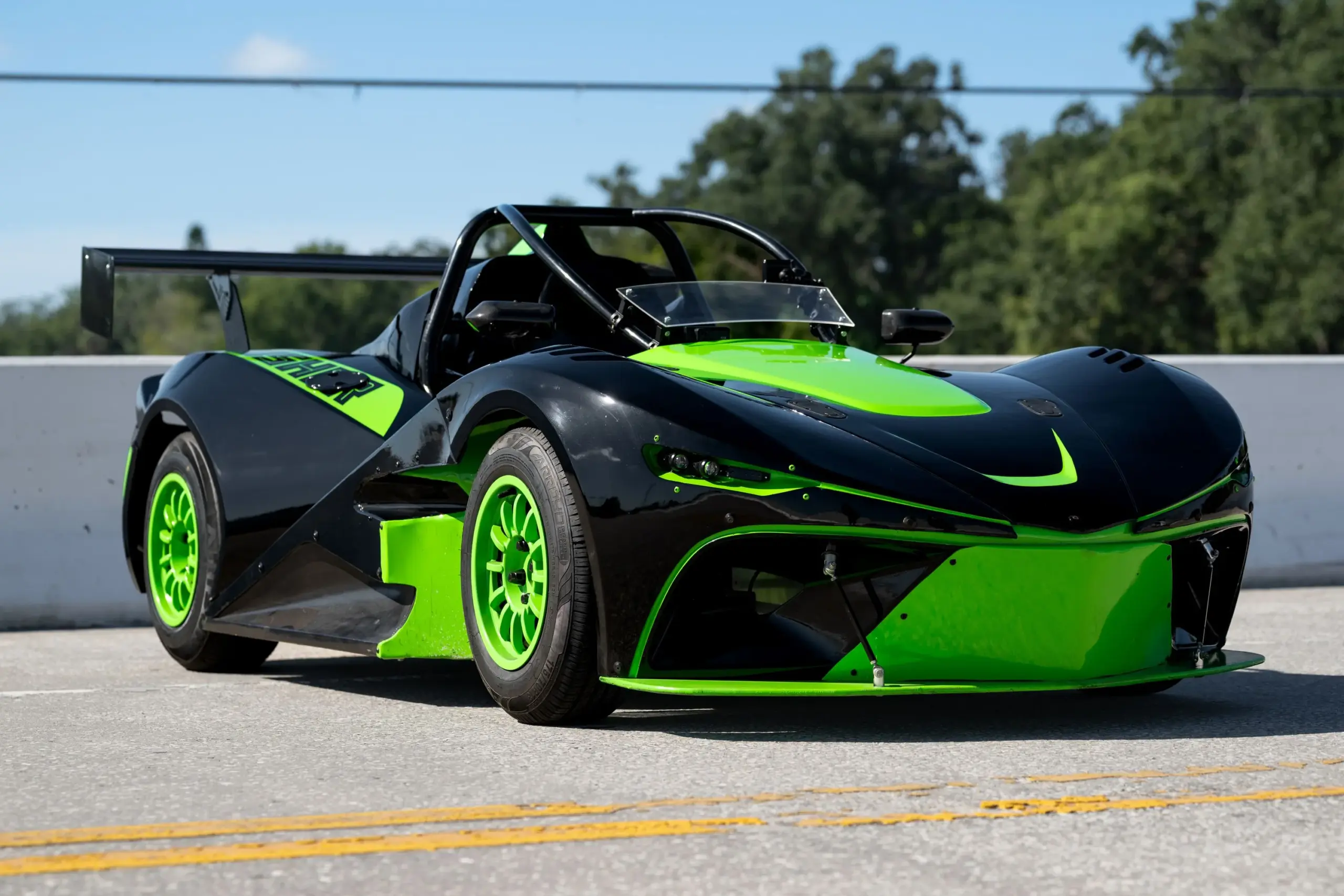 Frontansicht eines Newstar BG „The Crusher“ im zweifarbigen Schwarz-Neon-Grün-Look auf einer Straße, mit Carbon-Anbauteilen und markantem Heckflügel.