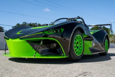 Newstar BG „The Crusher“ in Schwarz mit neon-grünen Akzenten, Frontansicht auf Asphaltstrecke, sportliches Einzelstück mit Flügel und grünen Felgen.