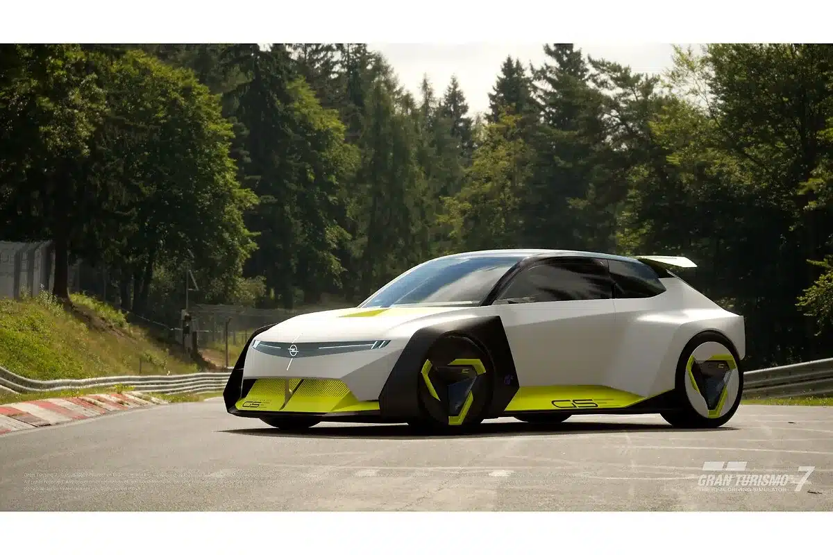 Opel Corsa GSE Vision Gran Turismo Konzeptfahrzeug auf einer Rennstrecke, futuristisches Design mit gelben Akzenten, umgeben von Wald.