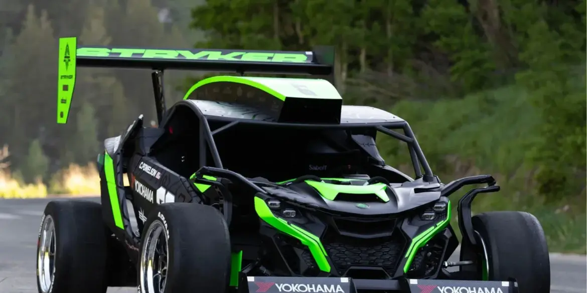 Der Stryker Rogue Maverick mit auffälliger Aerodynamik und großem Heckflügel auf einer Straße im Grünen.