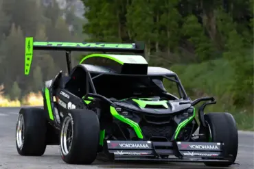 Der Stryker Rogue Maverick mit auffälliger Aerodynamik und großem Heckflügel auf einer Straße im Grünen.