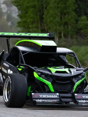 Der Stryker Rogue Maverick mit auffälliger Aerodynamik und großem Heckflügel auf einer Straße im Grünen.