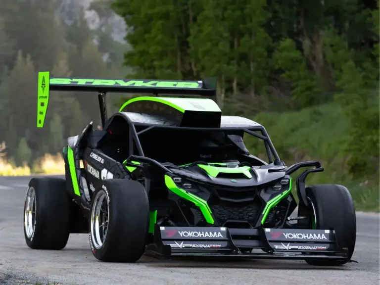 Der Stryker Rogue Maverick mit auffälliger Aerodynamik und großem Heckflügel auf einer Straße im Grünen.