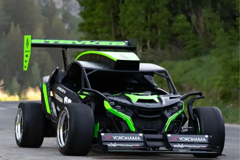 Der Stryker Rogue Maverick mit auffälliger Aerodynamik und großem Heckflügel auf einer Straße im Grünen.