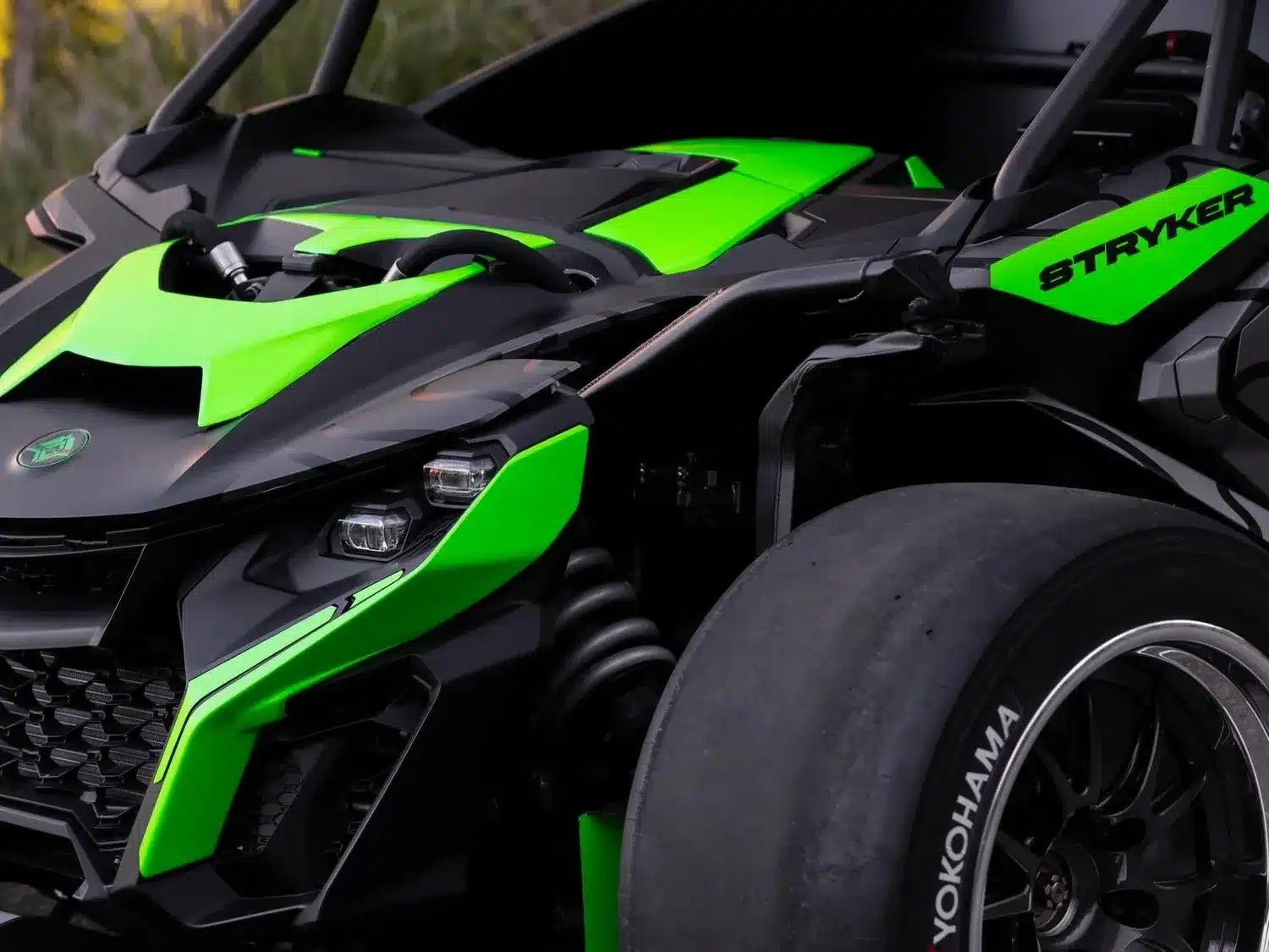 Nahaufnahme der Front des Stryker Rogue Maverick mit markantem Aero-Paket in Grün und Schwarz, Sicht auf Scheinwerfer und Aufhängung.