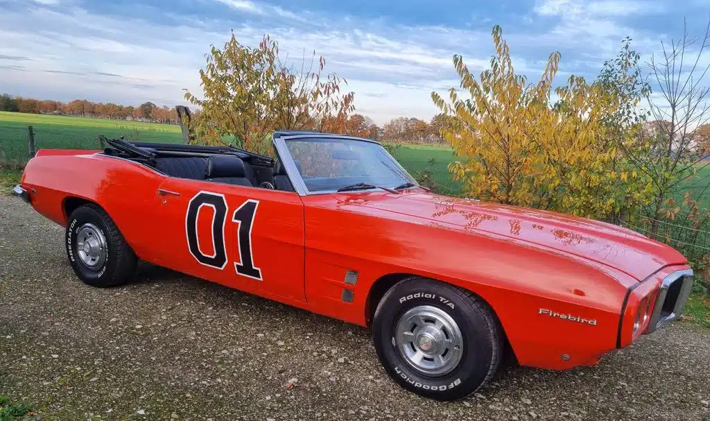 Pontiac Firebird Cabriolet 1969, orange, offen, Seitenansicht mit der Nummer 01 auf der Tür.