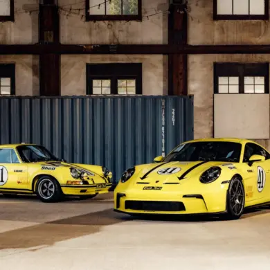 Porsche 911 2.5 S/T von 1972 und moderner Porsche 911 S/T, beide in Hellgelb und Startnummer 41, stehen nebeneinander in einer Halle.