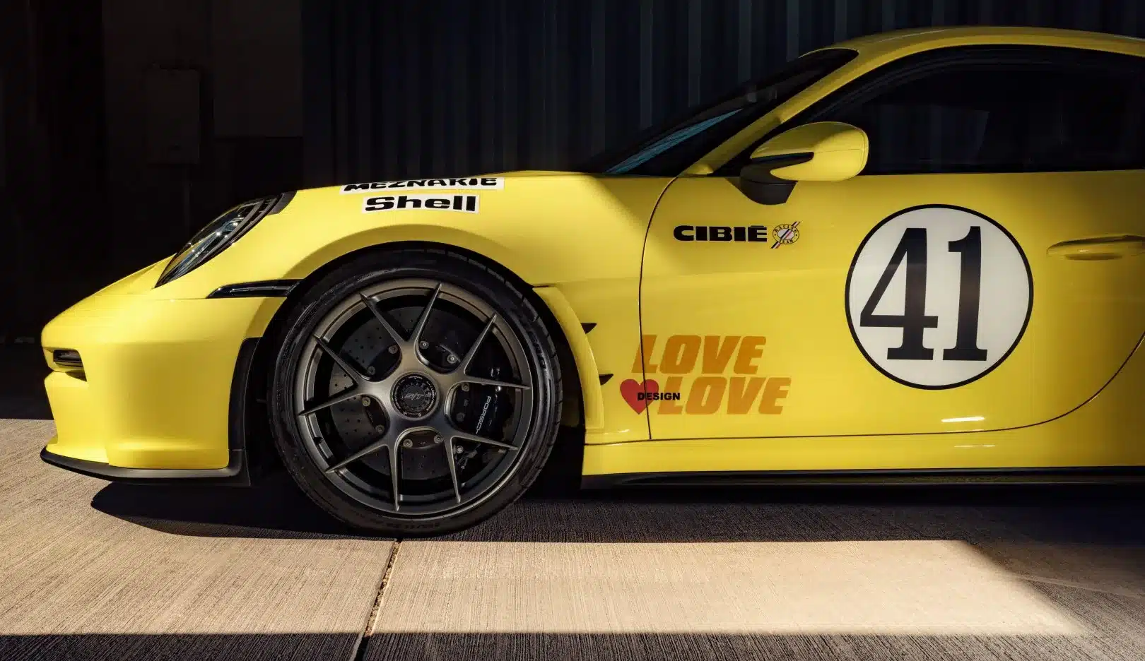 Seitenansicht eines gelben Porsche 911 S/T mit Startnummer 41 und Sponsorenaufklebern, inspiriert vom Le-Mans-Rennwagen von 1972.