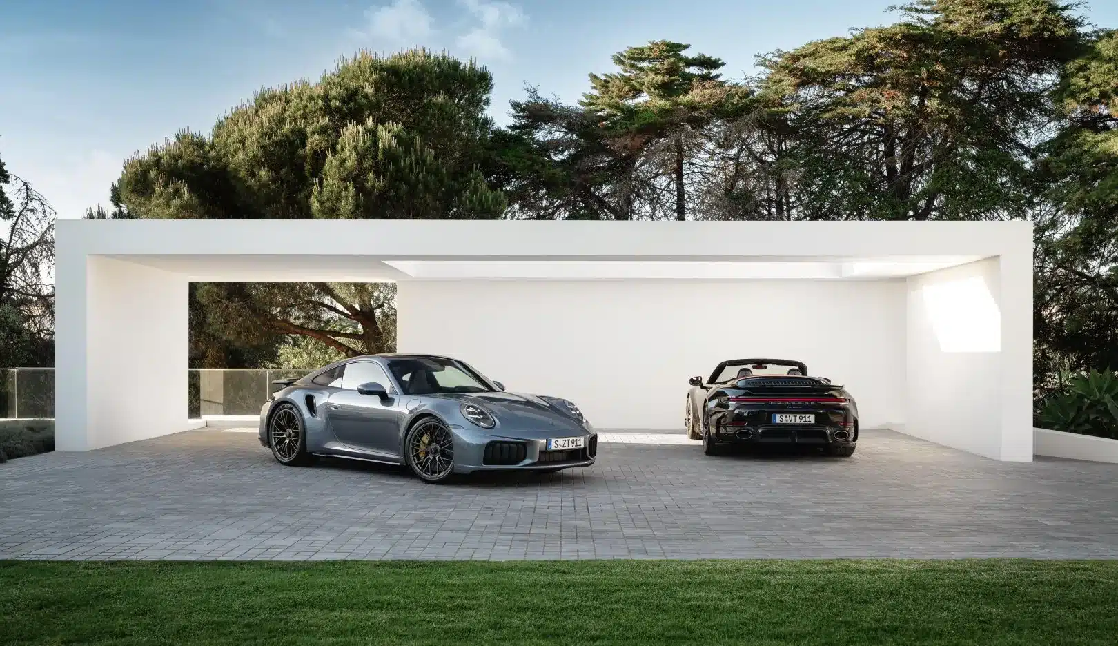 Porsche 911 Turbo S Coupé und Cabriolet der Generation 2025 vor moderner weißer Garage