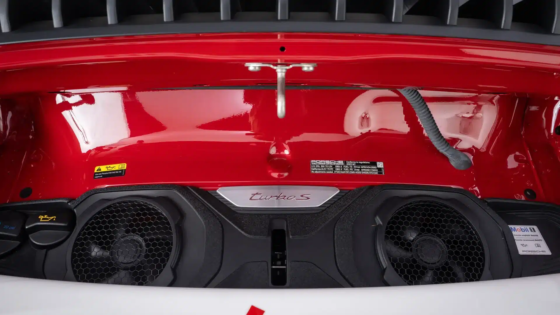 Motorraum des Porsche 911 Turbo S Lightweight 2022 mit Lüftungsgittern und 'turbo S'-Emblem.