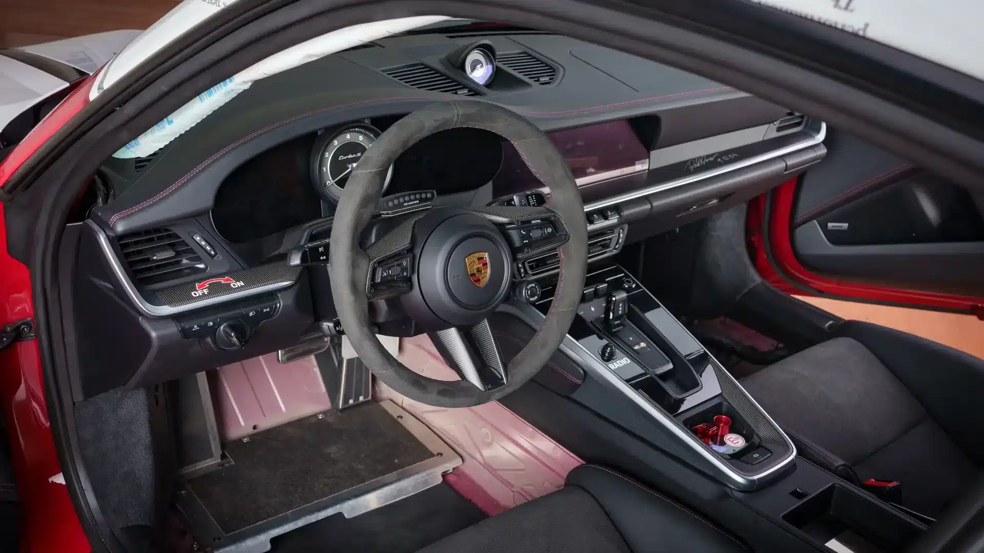 Cockpit des Porsche 911 Turbo S Lightweight 2022 mit Alcantara-Lenkrad, Carbon-Elementen und reduzierter Innenraumdämmung.
