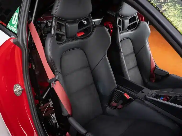 Carbonfaser-Schalensitze mit roten Sicherheitsgurten im Interieur eines Porsche 911 Turbo S Lightweight 2022, ohne Rückbank.
