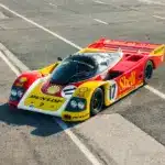 Porsche 962-010 in Shell/Dunlop-Rennlackierung auf einer verlassenen Rennstrecke.
