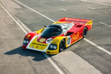 Porsche 962-010 in Shell/Dunlop-Rennlackierung auf einer verlassenen Rennstrecke.