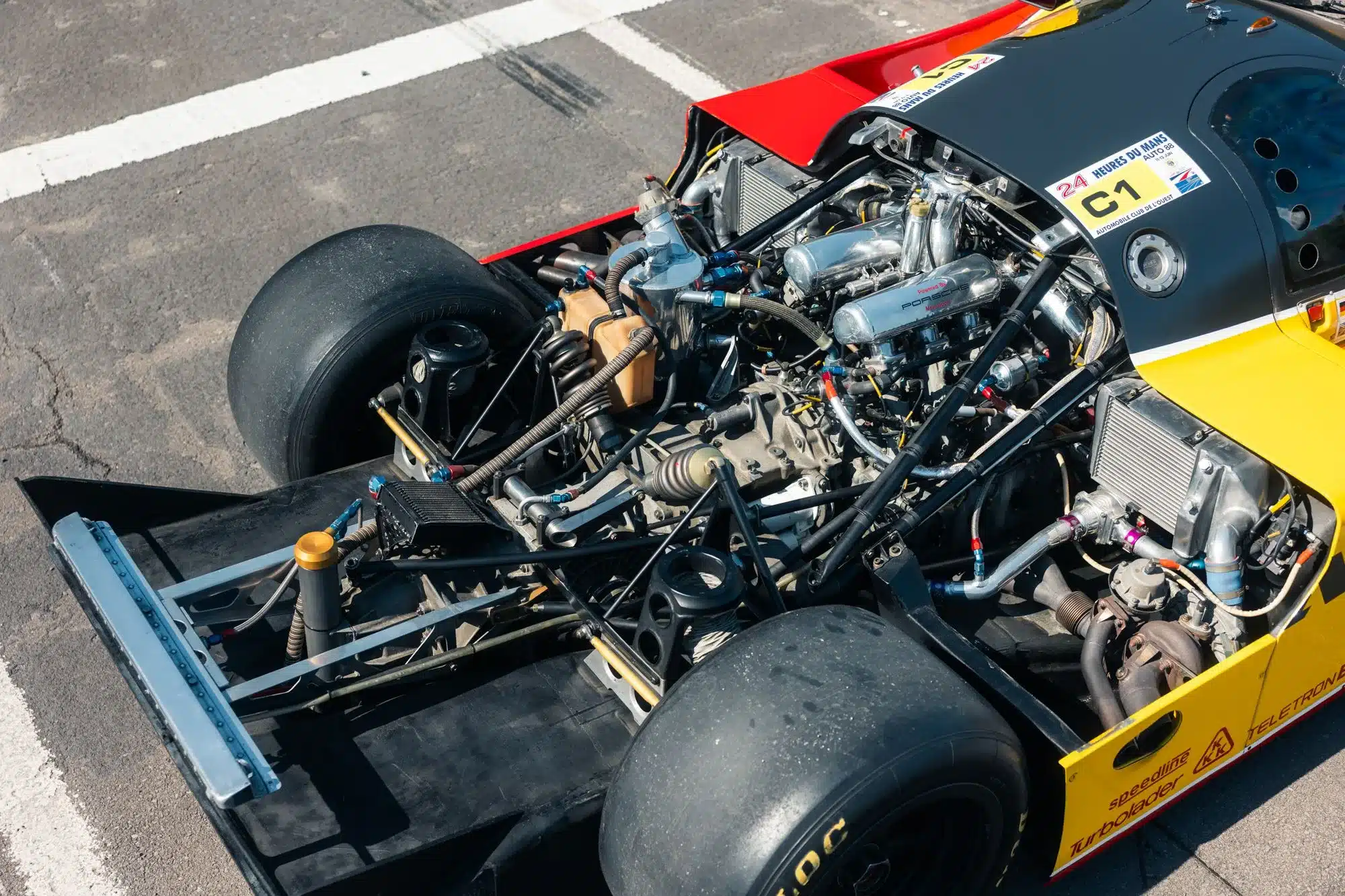 Freigelegter Boxermotor und Technik des Porsche 962-010 mit sichtbarer Shell/Dunlop-Lackierung.