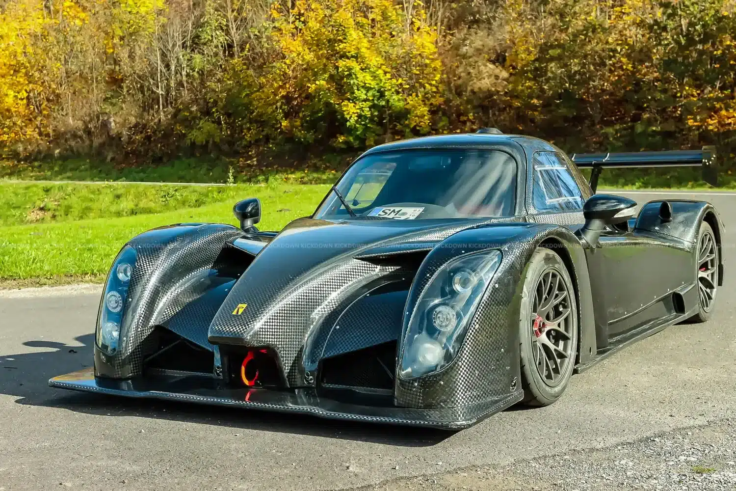 Radical RXC TwinTurbo GT 650R von vorn, schwarze Carbon-Karosserie, breite Front, Rennsportoptik, im Freien fotografiert.