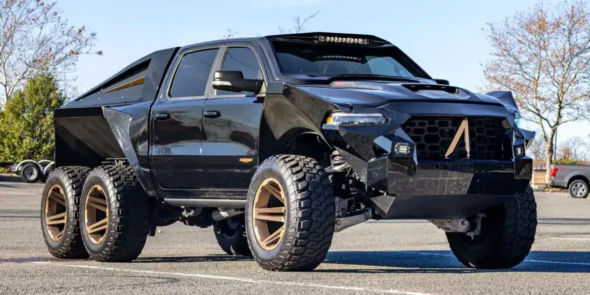 Apocalypse Juggernaut 6x6 Pickup, schwarz, mit sechs großen Offroad-Rädern, breiten Kotflügeln und massiver Front im Freien stehend.