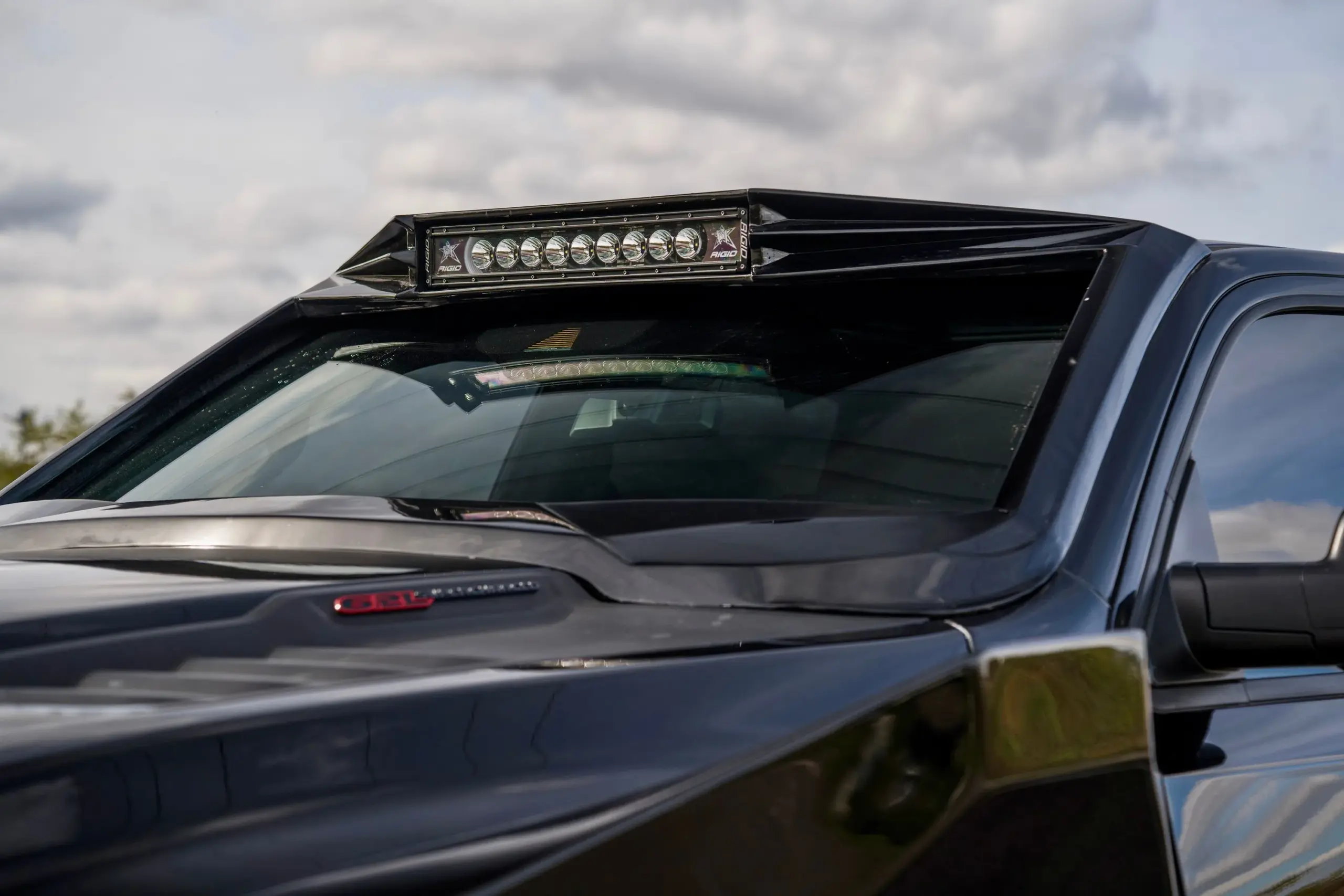 Nahaufnahme der LED-Lichtleiste und der Diamond Black Crystal Pearl-Motorhaube am Apocalypse Juggernaut 6x6 Pickup