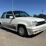 Renault 5 GT Turbo, weiße Kompaktlimousine mit Turbo-Schriftzug, Baujahr 1980er Jahre, von vorn schräg fotografiert.