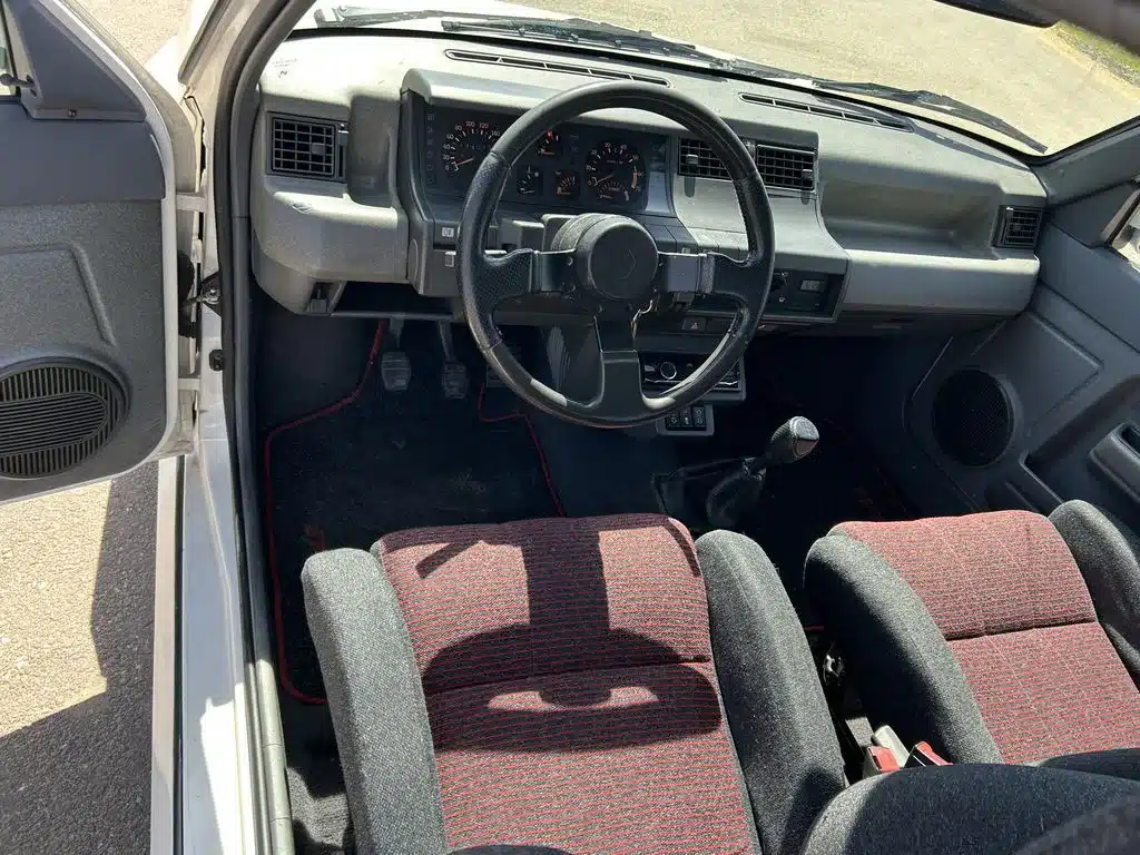 Innenraum eines Renault 5 GT Turbo mit Lenkrad, Schalthebel und Sportsitzen