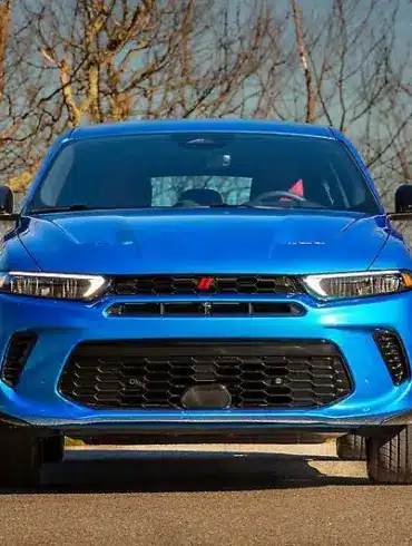 Frontansicht eines blauen Dodge SUV auf einer Straße mit kahlen Bäumen im Hintergrund