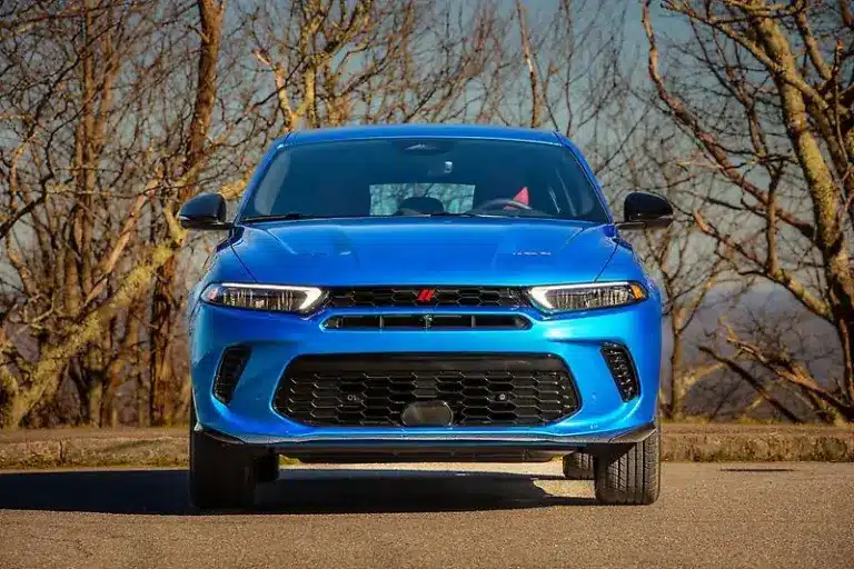 Frontansicht eines blauen Dodge SUV auf einer Straße mit kahlen Bäumen im Hintergrund