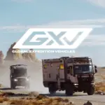 Zwei GXV-Expeditionsmobile fahren durch eine karge Felsenlandschaft, vorne ein großer LKW-basierter GXV Epic, dahinter der kompaktere GXV Hilt; darüber prangt das GXV-Logo.