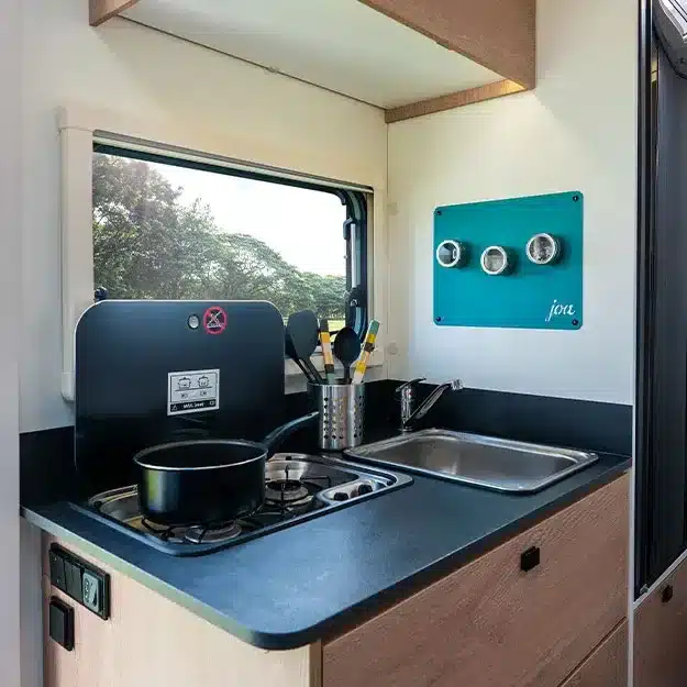 Moderne Wohnmobil-Küche mit Gasherd, Spüle und Zubehör im Teilintegrierten 60F.