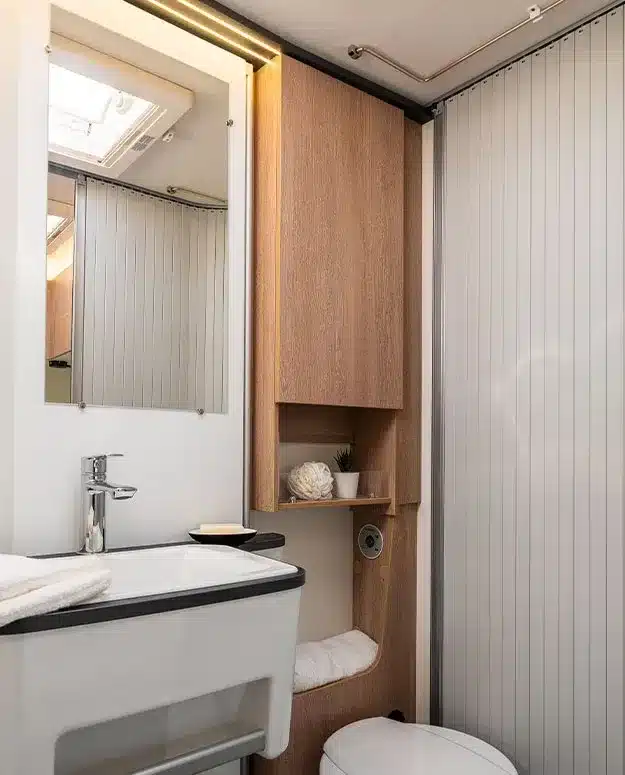 Innenansicht eines modernen Badezimmers im Wohnmobil 60F mit Holzdekor und praktischer Ausstattung