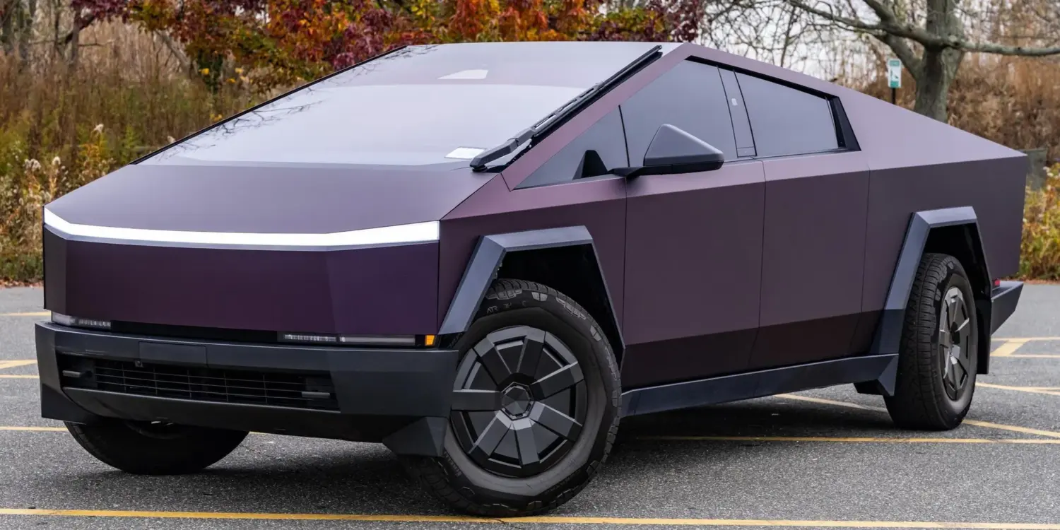 Tesla Cybertruck 2024 in violetter Lackierung, geparkt auf einem Außenparkplatz, markantes kantiges Design.