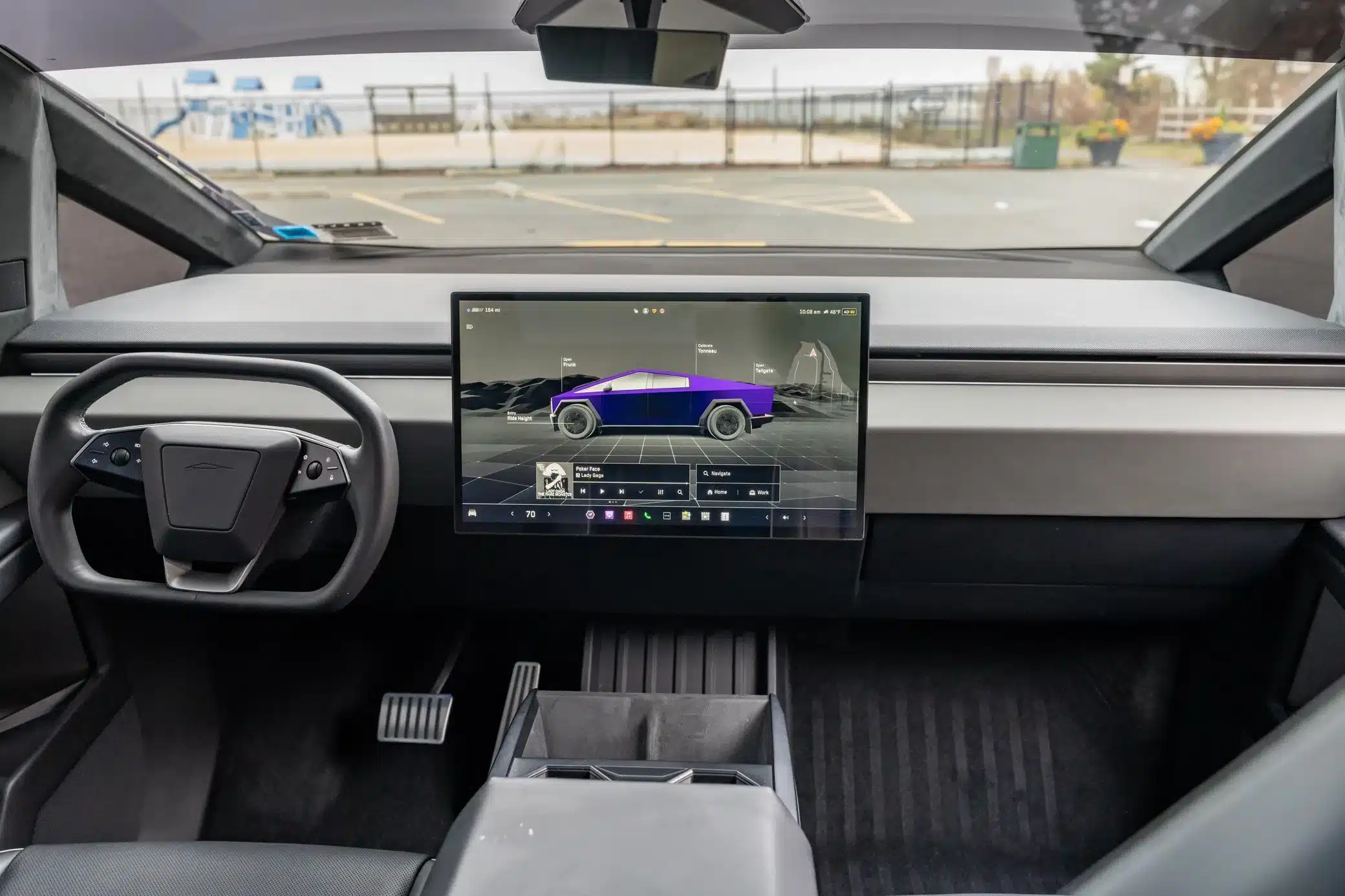 Innenansicht des Tesla Cybertruck 2024 mit markantem Lenkrad und zentralem Touchdisplay.