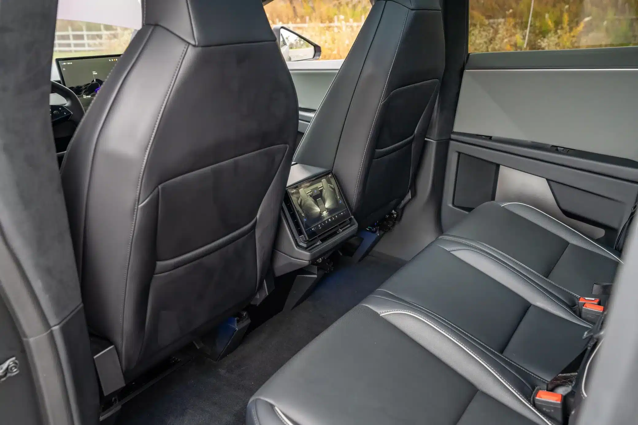 Rücksitzbereich mit Ledersitzen und Touchscreen-Bedienelement des Tesla Cybertruck 2024