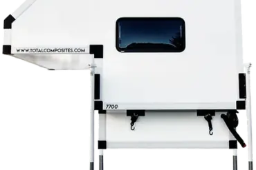 Seitenansicht einer weißen Absetzkabine von Total Composites auf vier Stützen mit Fenster und Befestigungspunkten