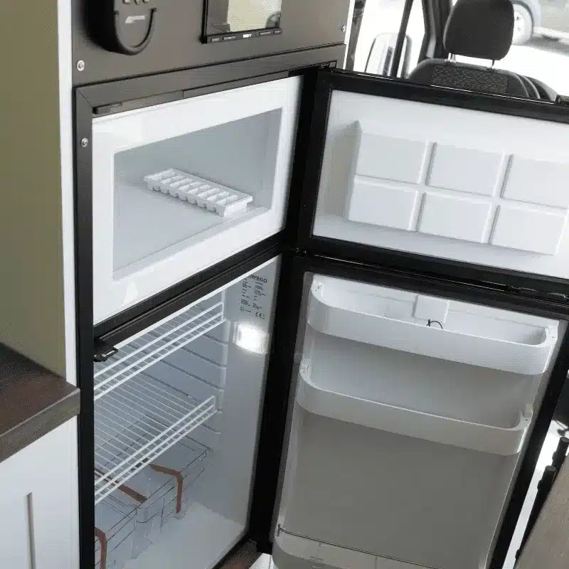 Offener Kühlschrank mit Gefrierfach im Innenraum eines Vancini Georgian Bay Sprinter-Campervans.