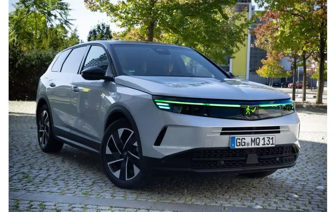 Vauxhall Grandland mit grüner Lichtsignatur und Fußgängersymbol an der Front als Demonstrationsfahrzeug für KI-gestützte Lichtkommunikation.