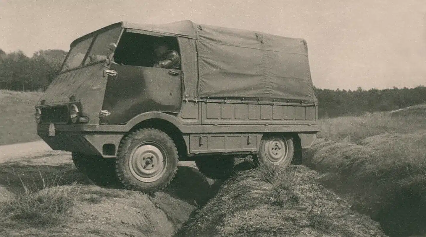 Historischer Škoda 998 Agromobil Geländewagen mit Plane fährt über unebenes Gelände.