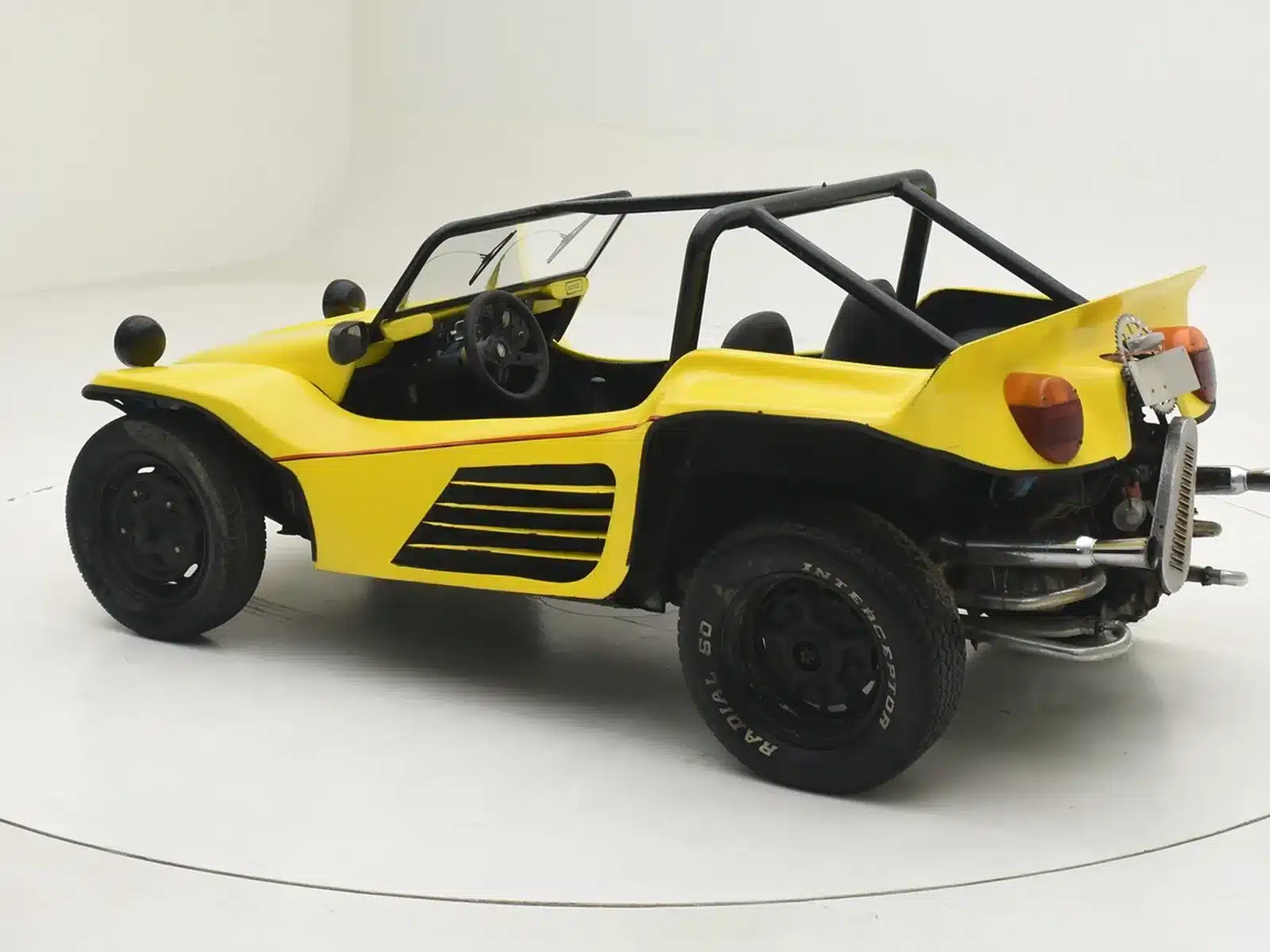 Seitenansicht eines gelben Volkswagen Buggy 1600, Baujahr 1962, mit offener Karosserie und Retro-Design.