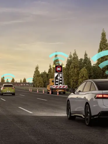 Mehrere Volkswagen-Modelle kommunizieren mittels Car2X-System auf einer Autobahn, dargestellt durch WLAN-Symbole über den Fahrzeugen und Baustellenanhängern.